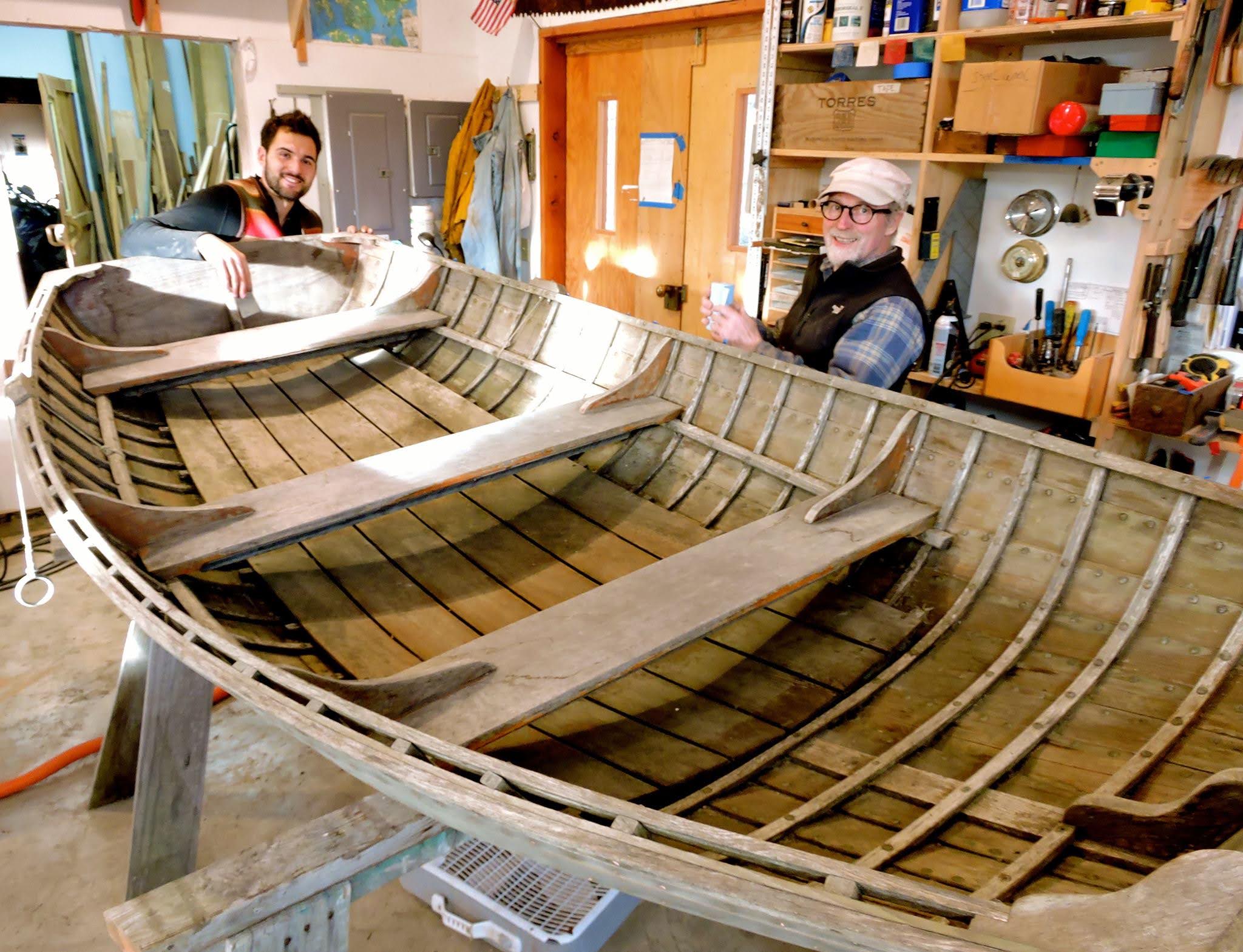 Craftspeople restoring a wooden boat in the workshop